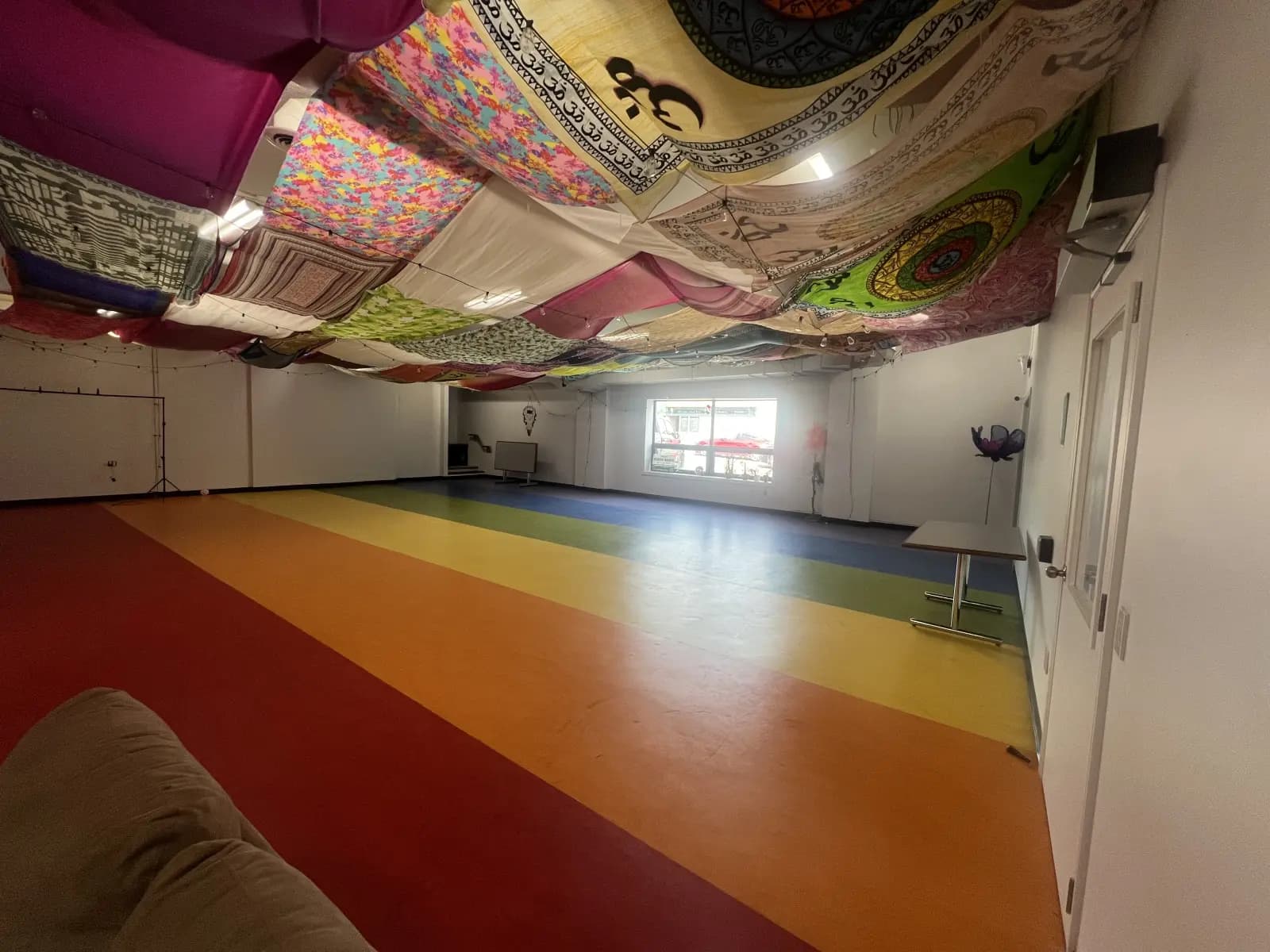 The Rainbow Room: a wide open hall with a floor painted in broad stripes of colour